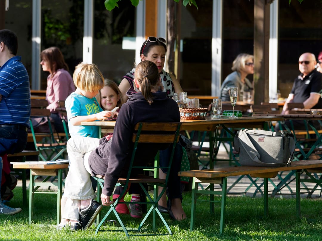 Gartentische mit Wein- und Wassergeschirr an einem sonnigen Sommertag